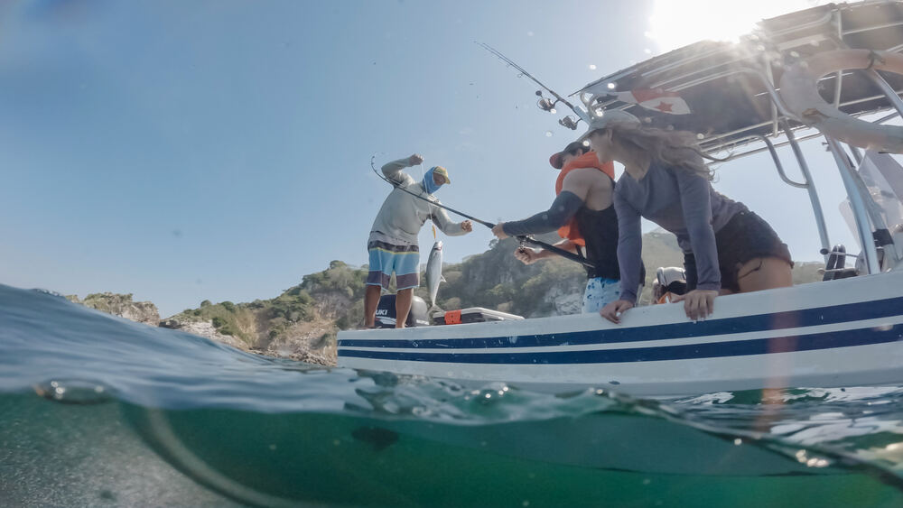 Guests reeling in a catch during a sportfishing trip